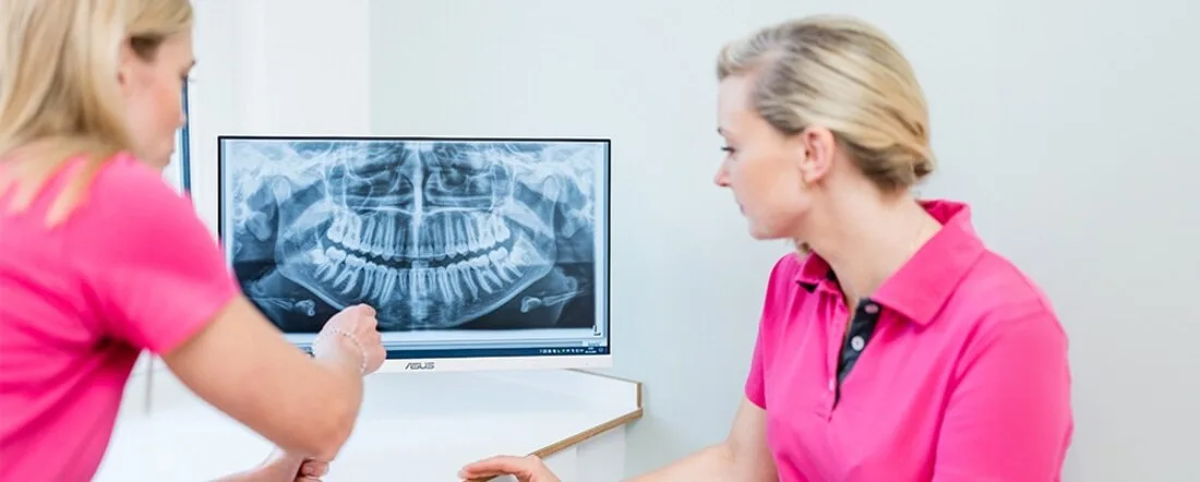 Zwei Mitarbeiterinnen der Kieferorthopädie Zähringen werten ein digitales Röntgenbild aus